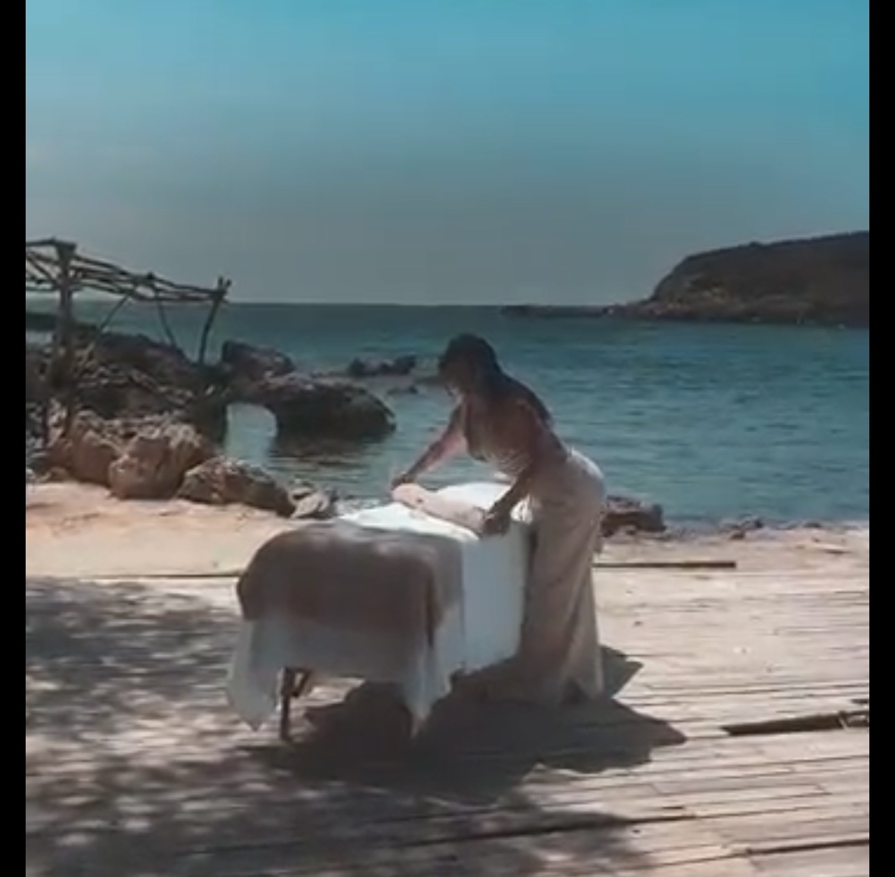 Parissa preparing a massage table on a seaside deck in Mallorca